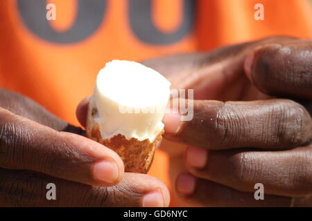 A local peeling a fresh cassava root by hand Stock Photo