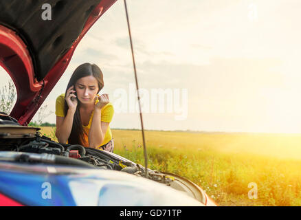 Woman calling emergency service near her broken car . Stock Photo