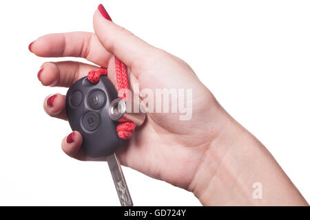 Close up of manicured hand with red nail polish holding black car key on white background Stock Photo