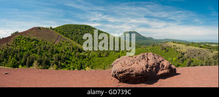 View towards Puy-de-Dome Volcano from Puy de la Vache Volcano, Auvergne, with large basaltic volcanic bomb in foreground Stock Photo