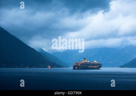 Boka Kotorska (the Bay of Kotor) from the village of Dobrota, Montenegro on a stormy evening: Mein Schiff 2 departing Kotor Stock Photo