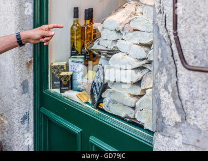 Finger pointing a storefront full of raw, dried and salted cod in Porto, Portugal. Stock Photo