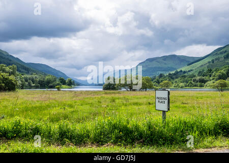 Beautiful Scottish scenery of Passing Place sign in front of Loch Voil near Balquhidder with hills and glens in the distance. Stock Photo