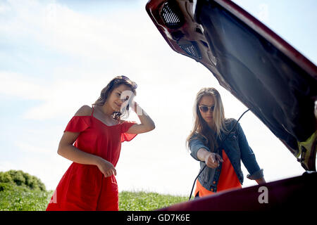 women with open hood of broken car at countryside Stock Photo