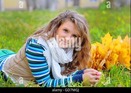 Young woman with autumn leaves in hand and fall yellow maple gar Stock Photo