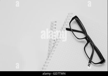 black plastic glasses on the opened notepad Stock Photo