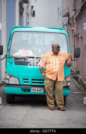 Barbados Parish Saint Michael local man male resting infant of his green truck isuzu waiting Stock Photo