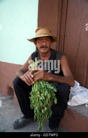 Portrait of a farmer wearing a straw hat sitting on a doorstep in Trinidad Cuba Stock Photo