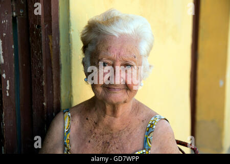 Portrait of an elderly half Spanish Cuban woman sits outside her home at the end of the day in Trinidad Cuba Stock Photo