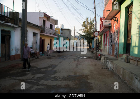 Cuban men hang around a neglected street of traditional houses in a rundown area of Trinidad Cuba Stock Photo