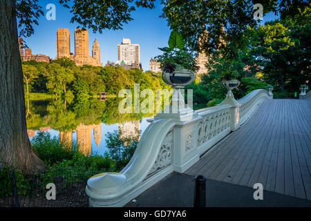 Bow Bridge in Central Park, New York City, with Upper West Side residential buildings visible in the distance Stock Photo