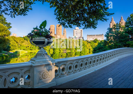 Bow Bridge in Central Park, New York City, with Upper West Side residential buildings visible in the distance Stock Photo