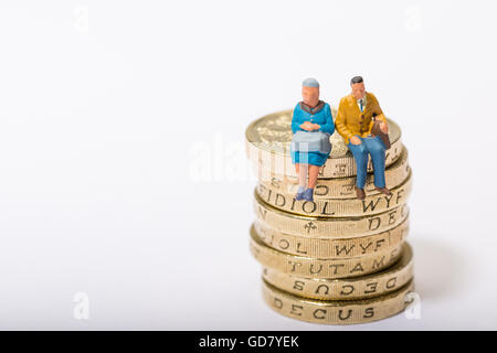 Concept image of two pensioners sat on a pile of pound coins Stock Photo