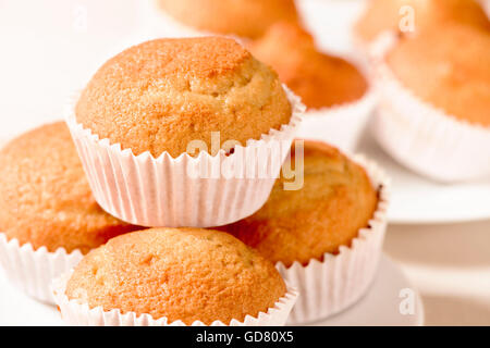 closeup of some appetizing plain muffins in a white ceramic plate on a set table Stock Photo