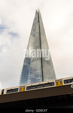 The Shard, London, towers over a passing train as it arrives into London Bridge station. Stock Photo