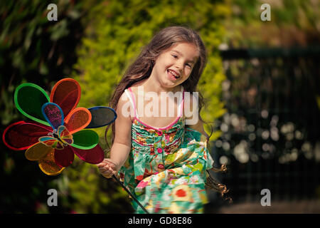 Girl playing with toy windmill Stock Photo