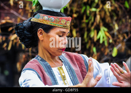 A Traditional Batak Dancer performing a ceremonial dance in Bolon Simanindo Batak Museum Village. Stock Photo