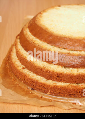 Cutting cake into layers. Making torte with buttercream filling and grated chocolate topping. Series. Stock Photo