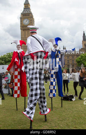 London, UK. 13th July 2016.   Three  colourful clowns on stilts parade in parliament Square on the day Theresa May becomes new British Prime Minister Credit:  amer ghazzal/Alamy Live News Stock Photo