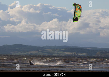 West End Beach, Morecambe, Lancashire, United Kingdom, 13th July 2016.  Wind Surfers off Morecambes West End beach take in the evening sunshine in the bracing off shore winds. Credit:  David Billinge/Alamy Live News Stock Photo