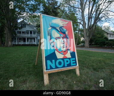 Lexington, Massachusetts, USA.  13th July, 2016.  A Lexington, MA, democrat made a 3 foot by 5 foot poster protesting the Republican Presidential candidate, Donald Trump, mounted it on a homemade wooden easel and placed it in his front yard on Massachusetts Avenue near central Lexington.    Credit:  Chuck Nacke/Alamy Live News Stock Photo