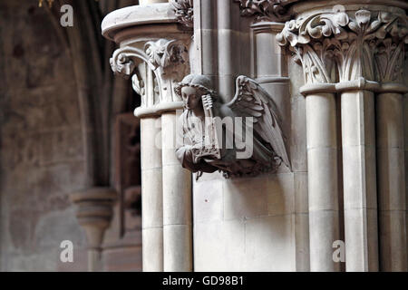 stone carving of an angel playing a small pipe organ. Lichfield Cathedral, staffs, UK Stock Photo