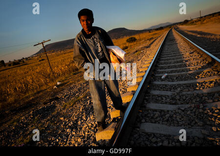 A Guatemalan immigrant waits on the railroad track to climb up the cargo train passing through Huehuetoca, Mexico. Stock Photo