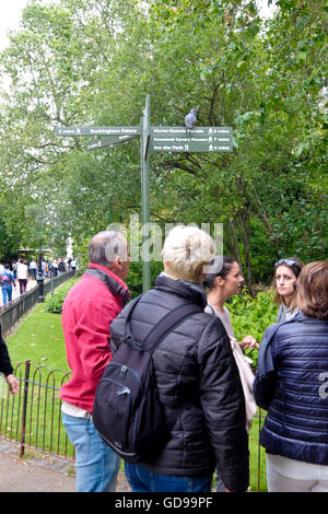 Tourists gather below an information direction sign in St James's Park on The Princess of Wales memorial walk Stock Photo