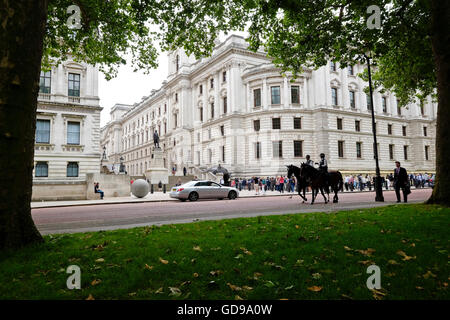 Police on horseback patrol past The Imperial War museum viewed from St James's Park Stock Photo