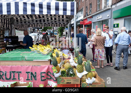 Brentwood UK. Customers buying fresh fruit set out on a farmers flea market stall on a High Street in Brentwood Essex England Stock Photo