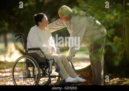 Man talking to a woman in a wheelchair Stock Photo