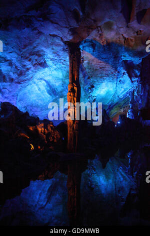 Multicolored lighting illuminating a stalactite and limestone rock formations in the karstics Reed Flute Cave, Guilin, China. Stock Photo