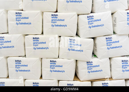 Stacks of British white granulated sugar by Sainsbury's stacked on a supermarket shelf. Stock Photo