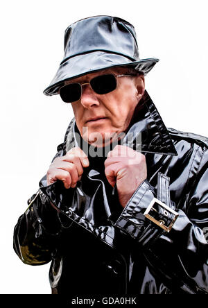 Menacing man in black pvc trench coat and hat Stock Photo