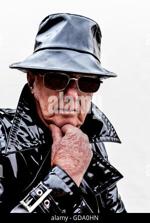 Menacing man in black pvc raincoat Stock Photo
