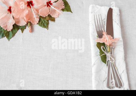 Pink Hibiscus flowers table setting background, toning Stock Photo