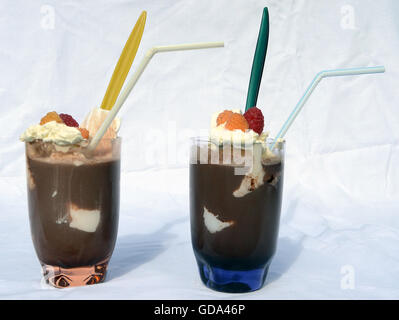 Two cocoa drinks with ice and cream, and yellow and red raspberries. Stock Photo