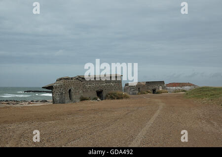 Bunkers and strong points from Hitler's Atlantic wall remains at the beach of Thyborøn. Erosion has moved or tilted some of them Stock Photo