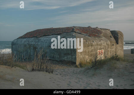 Bunkers and strong points from Hitler's Atlantic wall remains at the beach of Thyborøn. Erosion has moved or tilted some of them Stock Photo