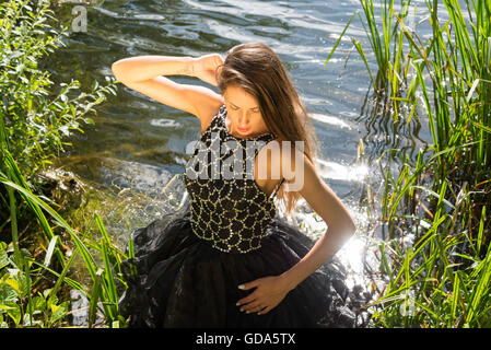 Young female model (20's) on photo shoot in river, Colnbrook, Berkshire, England, United Kingdom Stock Photo