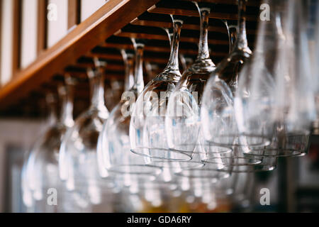 Glasses hanging over bar rack. Empty glasses for wine above a bar rack Stock Photo