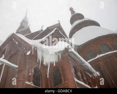 Germany, Lower Saxony, Goslar, Icicles depend on the snow-covered roof of the church in Hahnenklee, after a long-leg tour in the Harz Mountains Stock Photo