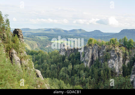 Germany, Saxony, Saxon Switzerland, rocks between pine forests, hike around the Bastei, the monk (left rock) in the background the Table Mountain Stock Photo