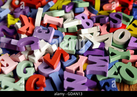 Heap of wooden  colored alphabet letters close up Stock Photo