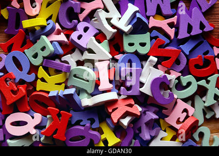 Heap of wooden  colored alphabet letters close up Stock Photo