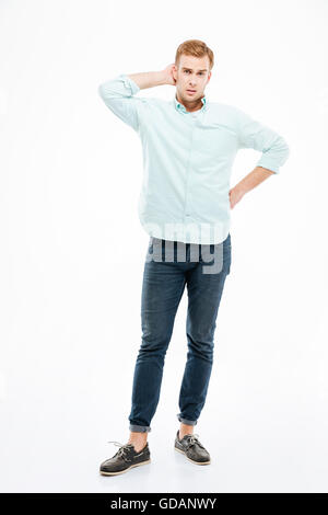 Full length of thoughtful young man standing and thinking over white background Stock Photo