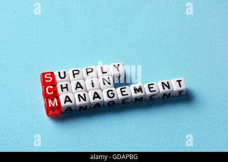 SCM Supply Chain Management written on dices on blue background Stock Photo