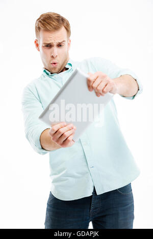 Portrait of a funny redhead man using tablet computer isolated on a white background Stock Photo