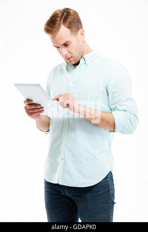 Portrait of a young redhead man using tablet computer isolated on a white background Stock Photo