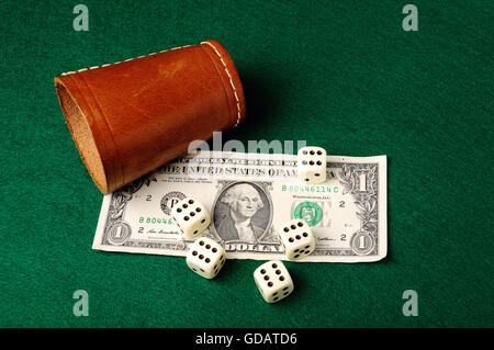 Dices, leather cup and dollar bill   on green cloth Stock Photo